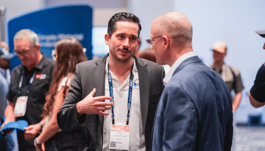 Pancho talking with a man on trade floor. 